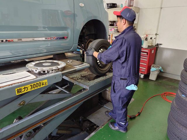 リフトで車を上げてタイヤを交換するスタッフ